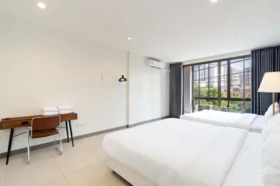 a white bedroom with a desk and a bed at Grand 3BR Townhouse in the Heart of BKK - Emsphere in Khlong Toei