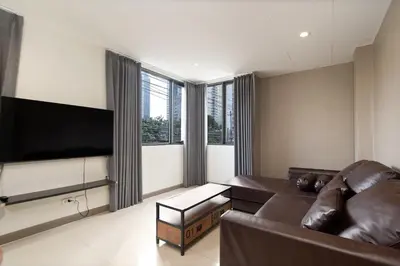 a living room with a couch and a flat screen tv at Grand 3BR Townhouse in the Heart of BKK - Emsphere in Khlong Toei