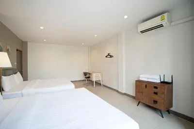 a hotel room with two beds and a air conditioner at Grand 3BR Townhouse in the Heart of BKK - Emsphere in Khlong Toei