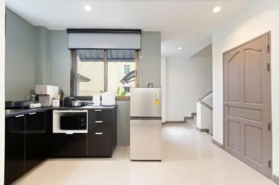 a kitchen with a refrigerator and a microwave at Grand 3BR Townhouse in the Heart of BKK - Emsphere in Khlong Toei