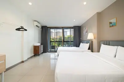 a hotel room with two beds and a window at Grand 3BR Townhouse in the Heart of BKK - Emsphere in Khlong Toei