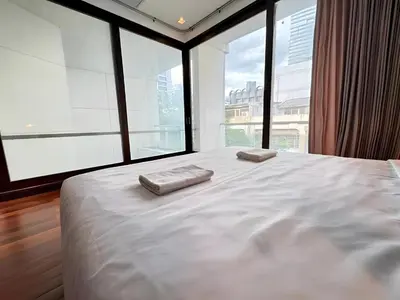 a bedroom with a large bed with two towels on it at Wish Inn Silom - Decho Bangkok City in Bang Rak