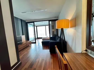 a living room with a couch and a television at Wish Inn Silom - Decho Bangkok City in Bang Rak