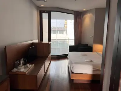 a hotel room with a bed and a window at Wish Inn Silom - Decho Bangkok City in Bang Rak
