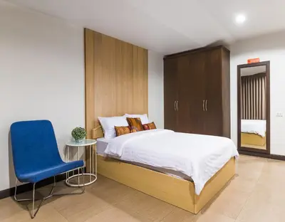 a bedroom with a bed and a blue chair at BB Garden Resort in Bangkok