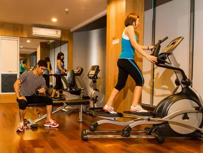 a man and a woman on a treadmill in a gym at BB Garden Resort in Bangkok