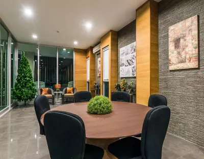 a conference room with a wooden table and chairs at BB Garden Resort in Bangkok