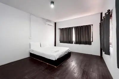 a bedroom with a bed with white sheets and a window at xx Mitr inn Khaosan ถนนตะนาว in Bangkok