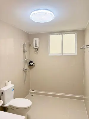 a white bathroom with a toilet and a window at 166 Living in Bangkok