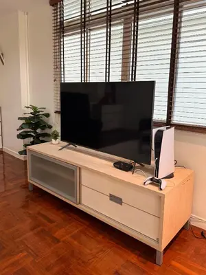 a large flat screen tv on a wooden entertainment center at 166 Living in Bangkok