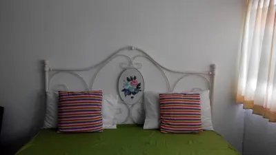 a bed with a white headboard and two pillows at Asia Don Mueang Bangkok Condominium in Nonthaburi