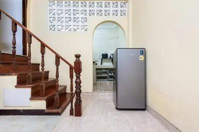 a refrigerator in a room with a staircase at High Friend Hostel in Phra Khanong