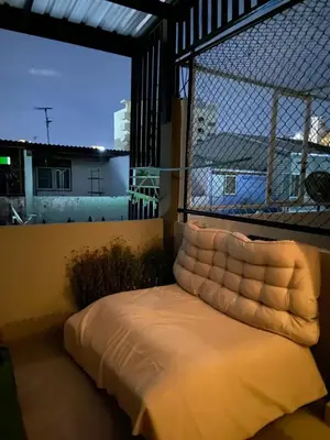 a bed in a room with a large window at High Friend Hostel in Phra Khanong