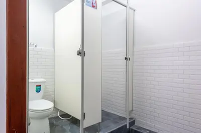 a bathroom with a toilet and a glass shower stall at High Friend Hostel in Phra Khanong