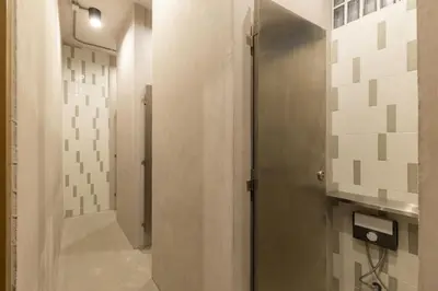 a bathroom with a shower and a door in a room at The District Hostel Ekkamai in Sathani Khlong Tan