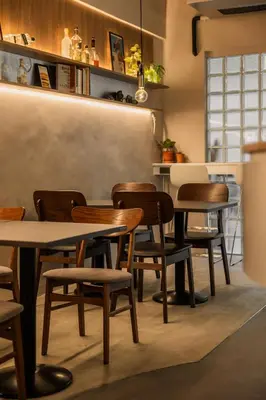 a restaurant with tables and chairs in a room at The District Hostel Ekkamai in Sathani Khlong Tan