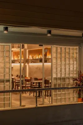 a window of a dining room with a table and chairs at The District Hostel Ekkamai in Sathani Khlong Tan