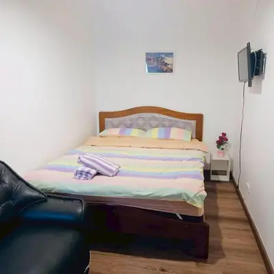 a bed in a room with a black leather couch at Boontharika Place Cozy Room Popular Condo near IMPACT Muangthong in Thung Si Kan