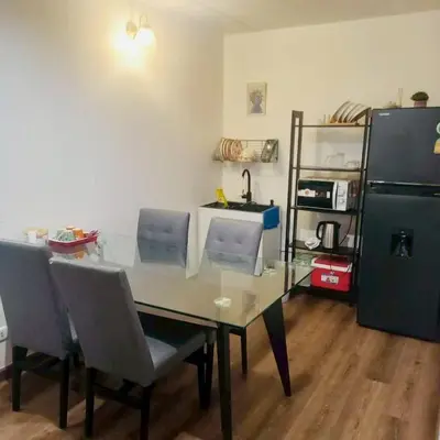 a dining room table with chairs and a refrigerator at Boontharika Place Cozy Room Popular Condo near IMPACT Muangthong in Thung Si Kan