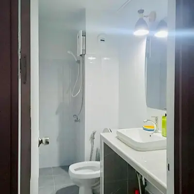 a white bathroom with a toilet and a sink at Boontharika Place Cozy Room Popular Condo near IMPACT Muangthong in Thung Si Kan