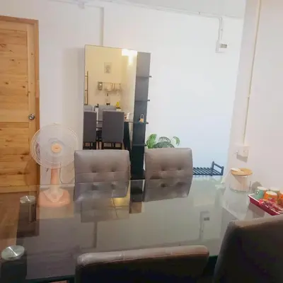 a living room with a glass table and chairs at Boontharika Place Cozy Room Popular Condo near IMPACT Muangthong in Thung Si Kan
