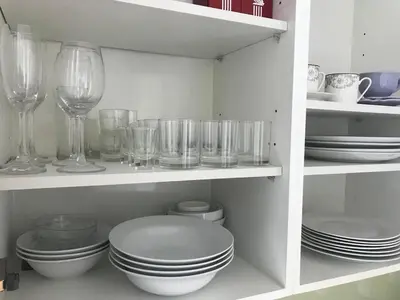 a shelf with plates and wine glasses and dishes at Walking distance to Sukhumvit soi 11 Netflix 40sqm in Makkasan