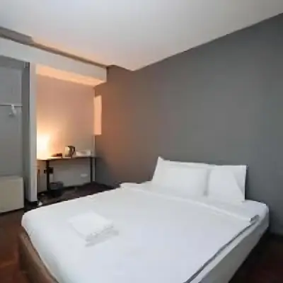 a large white bed in a small room at XX GO INN Silom - Bangrak BTS St Louis in Yan Nawa