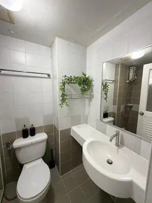 a white bathroom with a toilet and a sink at Stadium Area Stay Famous Thai Street Food in Bangkok