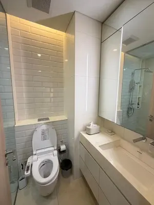 a bathroom with a toilet and a sink and a mirror at Sky Luxury Near BTS Ekkamai pool gym Netflix in Khlong Toei