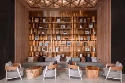 a living room with a couch and chairs and a book shelf at Sky Luxury Near BTS Ekkamai pool gym Netflix in Khlong Toei