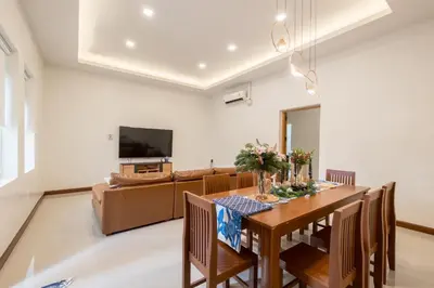 a dining room with a table and a couch at Baan Surawong 390 Heritag house in Chinatown
