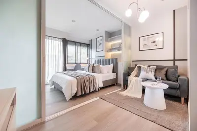 a bedroom with a bed and a couch and a table at 1 BR 5 Mins BTS Bearing 7-11 and Lotus in Ban Khlong Samrong