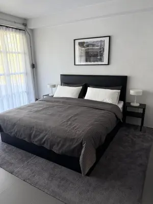 a bedroom with a large bed and a window at Sleepben in Bangkok