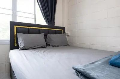 a bed with white sheets and pillows next to a window at ดอนเมือง 308 Near DMK Airport BTS Wat PhraSi in Bang Khen