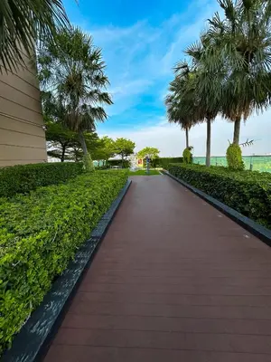 a walkway through a park with palm trees at Luxury Apt BTS EKKAMAI with pool sauna gym in Bangkok