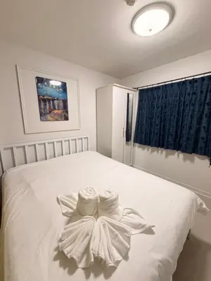 a bedroom with a white bed with two towels on it at Best Value Condo Lumpini Rajamangala in Sathani Khlong Tan