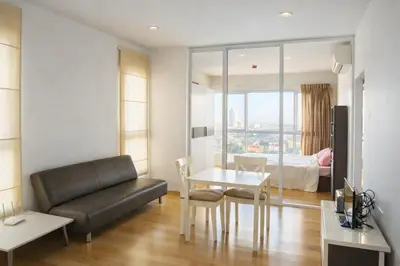 a living room with a couch and a table and a bed at Hive Sathorn SkyCorner Suite, BTS and 7-11 front in Bangkok
