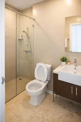 a bathroom with a toilet and a shower and a sink at Hive Sathorn SkyCorner Suite, BTS and 7-11 front in Bangkok