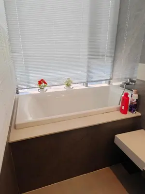 a white bath tub with two plants in a window at Modern 2BR-3 Mins Walking Distance to BTS Thonglor in Bangkok