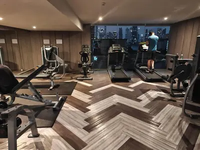 a man in a gym with a view of the city at Modern 2BR-3 Mins Walking Distance to BTS Thonglor in Bangkok