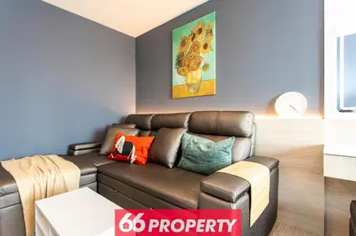 a living room with a brown couch with colorful pillows at Long-Stay High Floor Apartment, Bangna, Near BTS, Malls in Bang Chak