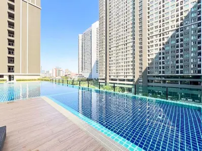 a large swimming pool in a city with tall buildings at Long-Stay High Floor Apartment, Bangna, Near BTS, Malls in Bang Chak