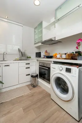 a white kitchen with a washing machine in it at Lucky 808 2BedRoom 100sqm BTS Chidlom in Bangkok