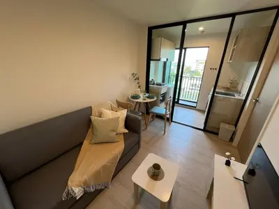 a living room with a couch and a table at Quiet apartment with pool close to MRT station in Bangna