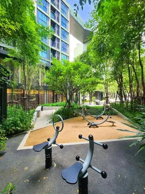 a group of exercise equipment in front of a building at Quiet apartment with pool close to MRT station in Bangna