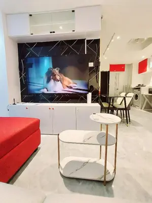 a living room with a tv and a red couch at Charming 2-Bedroom Apartment in ON-NUT, Bangkok in Amphoe Phra Khanong