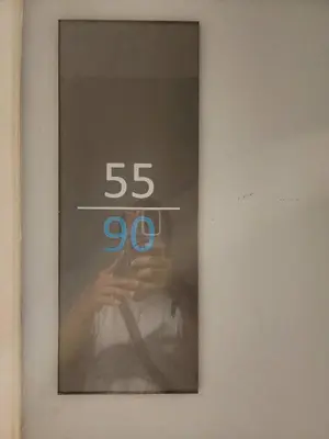 a reflection of a person in a mirror with a speed limit at Homely Condo Minimal Style Near BTS Silom line in Bang Khun Thian