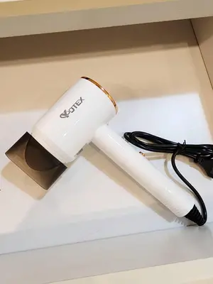 a white inhaler sitting on a table with a cord at Homely Condo Minimal Style Near BTS Silom line in Bang Khun Thian