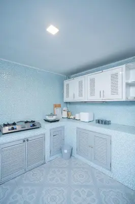 a kitchen with white cabinets and a blue wall at \u66fc\u8c37\u5e02\u4e2d\u5fc3\u7d20\u5764\u9038\u4e2d\u53e4\u98ce5\u53675\u536b2\u5385\u5ea6\u5047\u522b\u5885 in Sathani Khlong Tan