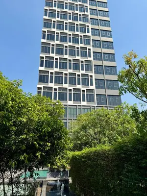 a tall white building with trees in front of it at 5 Min walk to BTS Onnut Duplex Loft At Sukhumvit in Amphoe Phra Khanong